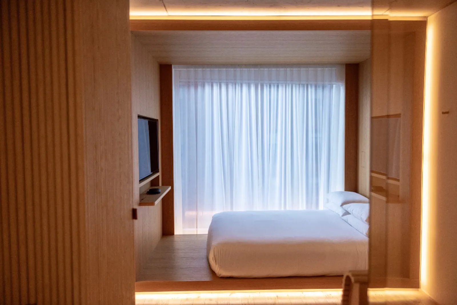 Warm bedroom with concealed cove lighting and motorised sheer curtains